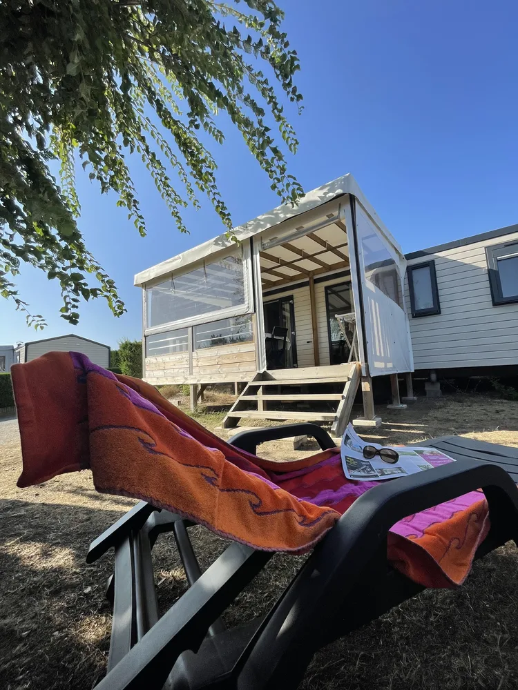 Détente sur un transat devant un mobil-home au Camping l'Eden