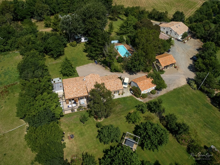 Vue aérienne d'un camping à la ferme aux Sables d'Olonne montrant la piscine sécurisée et le corps de ferme traditionnel