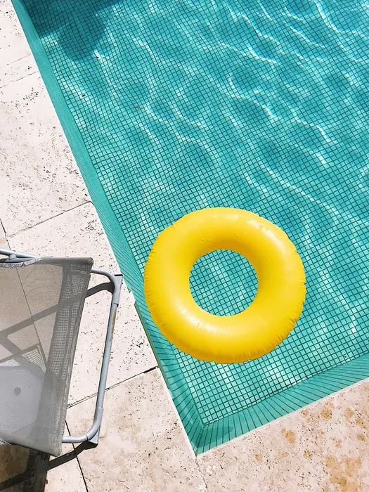Un coin de piscine chauffée avec une bouée jaune